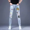 Versão coreana dos homens nobre azul jeans de alta qualidade magro estiramento jeans luz luxo impressão jeans elegante sexy rua jeans; HKD230829