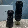 Shearling Apres Boots Ecru z miękkim dotykiem charakteryzuje się ich sportowym, ale wyrafinowanym allure'em emaliowanym metalowym trójkątem dekoruje akcesorium buta narciarskiego