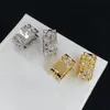 Boucles d'oreilles huggie de marque 2023. Créateur de boucles d'oreilles de luxe en plaqué or 18 carats et strass plaqué argent pour femme. Bijoux de créateur tendance haut de gamme avec écrin