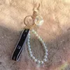 Chaveiro de designer de marca de luxo chaveiro feminino moda segurança chaveiro pérola fita anel bolsa pingente cordões para estojos de fone de ouvido