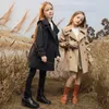 子供用の長いテンチコートは、西洋化された中程度と老齢の子供のコットンコートミディアムとロングスタイルの女の子のウィンドブレーカー韓国語バージョンの韓国語バージョンを着る