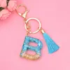 Nyckelringar Ny mode English Letter Keychain Wi Tassel Blue A-Z Keyring Glitter Sequins Filling Harts Nyckelkedjiga gåvor Tillbehör L230314