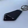 Diseñador de llavero Simplemente llave negra con letras de triángulo de metal de cuero ordinario Portachiavi Soft portátiles Bag Bag Key Hebilla Ornamentos PJ056 B23