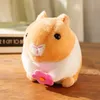 Um hamster fofo com uma cauda abanada, uma boneca de brinquedo de pelúcia, um coelho, uma boneca de cordas, um presente de aniversário de ano novo