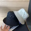 Nylon designer mössor för man hink hatt vikbara kvinnor resande shopping metall triangel cappello cool tjej presenterar trendiga lyxiga hattar fast färg PJ006 C23