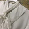 Damskie bluzki projekt marki elegancki kołnierz dziecięcy biała koszula francuska słodka długotropiwana krótka ciężka robota bluzka z koralikami 2023 Wiosenna koreańska