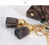 Lederen sleutelhangers ringen sieraden bruine bloem plaid kwast munt portemonnee hangende mode mode mini opbergzak charm sleutelhangers accessoires 7 kleuren