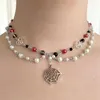 Girocollo Collana fatta a mano in stile rosario con perle di vetro rosse e nere scoppiettanti - doppio strato con ciondolo a ragnatela