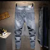 Jeans da uomo Uomo New Strappato Casual Jeans skinny Pantaloni Moda Uomo di marca streetwear Lettera stampata in difficoltà Foro grigio Pantaloni in denim 201123 L230520