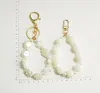 Porte-clés Designer De Luxe Camélia Vintage Imitation Perle Chaîne Porte-clés Sac Pendentif Charme Bijoux Airpods Accessoires D988