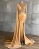 2023 Abiti da sera in oro sexy Indossare gioiello collo Illusion Mermaid Side Split Appliques in pizzo Perle di perline di cristallo Maniche lunghe Piuma Abito da festa formale Abiti da ballo