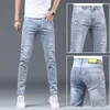 Jeans da uomo Estate alla moda Designer in stile coreano Foro strappato elasticizzato Denim blu Elegante fidanzato sottile da uomo