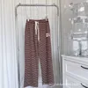 Dwuczęściowa marka projektantów damskich 2023 Autumn Casual Lazy Brown Three Set z Camisole, Striped Pants i Sweter Cardigan Aqyq