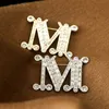 ピンブローチファッションクリスタルラインストーンレターMエナメル模倣真珠のブローチ女性バロック賭けイニシャルピンウェディングジュエリーブローチ231204