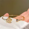 Bangle Luxury Rotable Zircon Four Leaf Grägguldfärg Koppar Öppna armband för kvinnor Nytt mode Avancerat bröllopsfest smycken gåva R231205