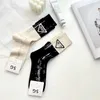 Meias meias europeias de alta qualidade femininas com letras de cola e cores combinando com agulha dupla meias de comprimento médio estilo de designer moderno e sujo E569