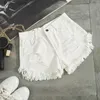 Nieuwe mode nieuwe zomer dames witte denim shorts sexy gat gescheurde mini jeans shorts dames streetwear kwastje hoge taille shortsL231215