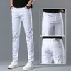 Jeans pour hommes Designer Printemps / Été Nouveau pour la lumière de luxe Édition coréenne Mince Pieds élastiques Slim Fit Coton Pur Blanc Pantalon long européen U8NM