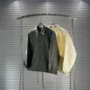 Chaqueta de entrenador de solapa de moda de diseñador para hombres y mujeres parejas con retazos bolsillos grandes estéreo sueltos