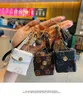 패션 디자이너 AirPodScase Keychains Trinkets PU 가죽 키 반지 체인 보석류 갈색 꽃 펜던트 가방 매력 키 링크 키 홀더 패션 액세서리