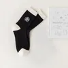 Chaussettes de sport Broderie japonaise noire Douce INS Confortable Camélia et Rose Bande verticale blanche Tube en pur coton