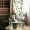 Vasen, schmaler Mund, transparente Glasvase, Glocke, getrunkenes Holz, Blumenarrangement im Wohnzimmer und Esstisch