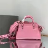 Handbag in pink lambskin aged-silver hardware trapezoidal shape shoulder bag two leather hand-braided handles with adjustable and removable strap