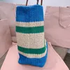 Classic designer tote bag Woven fabric vibrant color-block pattern animates this crochet handbag embroidered lettering shoulder bag leather handles