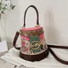 Factory wholesale ladies shoulder bags 2 colors street popular totem bucket bag trend western-style printed handbag thickened leather mobile phone coin purse 2210