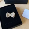 Luksusowe projektanty Bow Brooch Pins dla kobiet marka złota litera łuk broszka perłowa akcesoria diamentowe vintage żeńskie sukienki