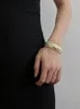 Nieregularna bransoletka w paski w paski z czarnym złotym luksusowym francuskiego niszowego projektanta z otwartą emaliowaną bransoletką