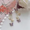 Kolczyki Dangle Koreańskie kolce mody biżuteria fioletowa symulacja motyla Pearl Stud Tassel Oświadczenie dla kobiet hurtowych