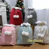 Decorazioni natalizie che vendono sacchi di Babbo Natale in velluto di colori tenui con grandi pompon, sacchetti regalo in peluche a sublimazione