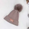 豪華な新生児のかぎ針編み帽子冬の親子デザイナーキッズハットファーボールデコレーションニットベビーキャップ11月