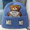 Cappello invernale a cuffia con polsino in tessuto ricamato del designer Moschino 2023