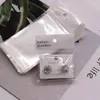 Smyckespåsar 100st vita transparenta självtätande OPP-väskor med hängande hål för örhänge halsband förpackningsdisplayleverantör