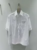 Novo conjunto de roupas esportivas de manga curta masculina e feminina de designer de luxo Camisa Família Triângulo Nylon Plissado 2023 Verão Nova Cintura Alta Versátil Saia Fina