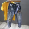 Mäns jeans broderade kamouflage -lapp jeans män modedesigner skarvade streetwear hane slitna rippade hål magra jeans denim byxor 230414