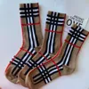 Les chaussettes à carreaux rayées à la mode européenne pour les manches de taille moyenne pour femmes sont populaires en streaming en direct en ligne avec les mêmes nouvelles piles d'automne et d'hiver