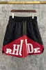 Ropa de diseñador Rhude Letter Trend Marca Empalme de dos colores Pantalones cortos a juego Pantalones de cinco puntos Estilo masculino High Street Ocio Parejas Joggers Ropa deportiva