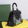 Klassische Designer-Taschenhandtasche. Modische Handtasche mit feinkörniger Design-Komposition aus Metallschildern