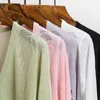Femmes tricots femmes printemps été creux voir à travers tricots Cardigan élégant dame col en v couleur unie mince Transparent tricot