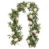 Dekorativa blommor konstgjorda kransar med ros hängande rotting eukalyptus bladblomma wisteria gröna växter vine bröllop bord löpare hem