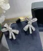女性のためのトレンディなクリスタルティルダ弓ピアス925スターリングシルバーアイスダイヤモンドジュエリーウェディングキューブジルコンボウノットイヤリング