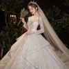 2023 أحدث فتيل ثوب زفاف فاخر طويل الأكمام ، فستان زفاف وهم أعلى ثيابين زفاف لؤلؤة من الدانتيل