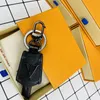Porte-clés en cuir de marque pendentif de mode porte-clés de voiture lettres de luxe fleur marron noir vieille fleur de haute qualité bibelot cadeaux porte-clés accessoires faits à la main