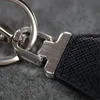 Fashion Keychains Mens Designers Keychain Keyrings For Woman Rostfritt st￥l Svart l￤der Luxury Key Chains Lanyards Car Key Ring Bag Charm