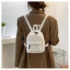 Bolsas escolares mini mochila de pelúcia de cor sólida mulheres meninas selvagens moda de outono de outono de inverno de inverno pequeno mochila pequena para a rua de compras