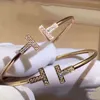 Bracciale aperto a doppia T del marchio originale Tiktok, tutto abbinato alla catena e alla stessa famiglia di gioielli.Con logo