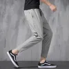 Pantaloni da uomo 2023 nuovi pantaloni elastici di seta del ghiaccio coreano quattro stagioni sottili pantaloni casual da uomo larghi 9 punti pantaloni sportivi a piede piccolo di grandi dimensioni primavera Z0225